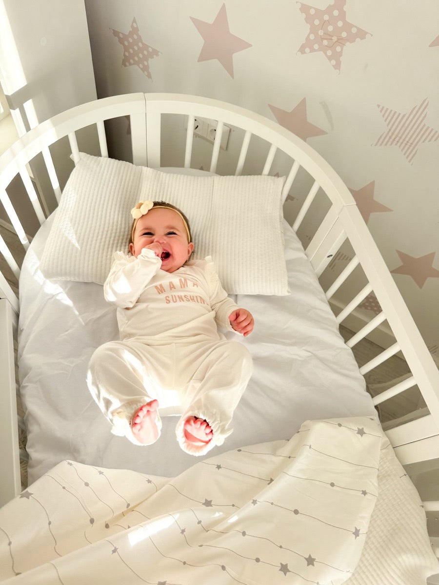 White round crib OLIN three-quarter view with two adjustable mattress height positions