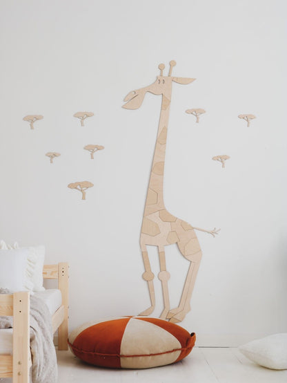Wooden giraffe wall sticker above bed with acacia tree details and coordinating wall decals in playroom