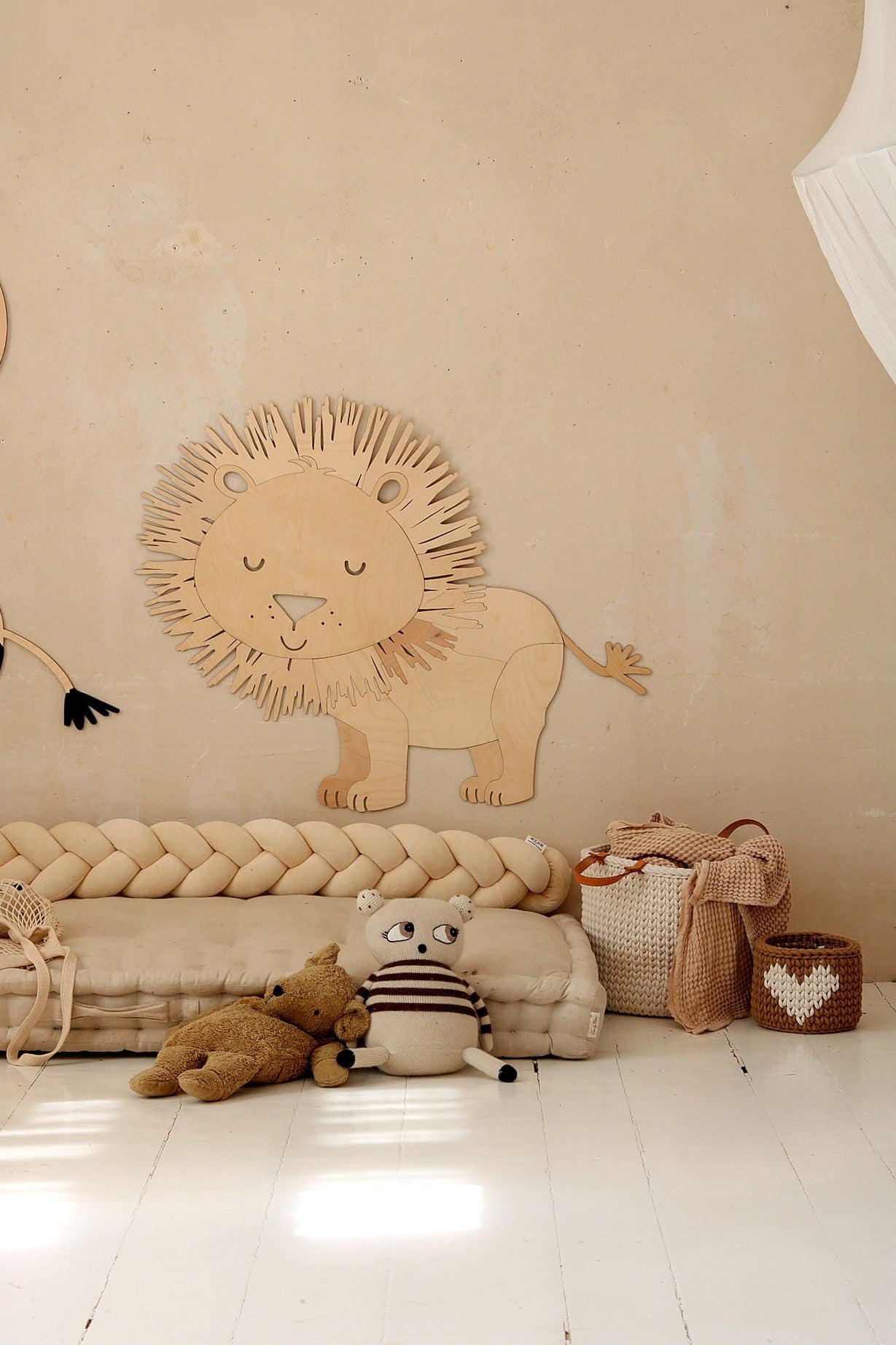 Safari lion wooden wall decoration positioned above rope floor mat in kids room