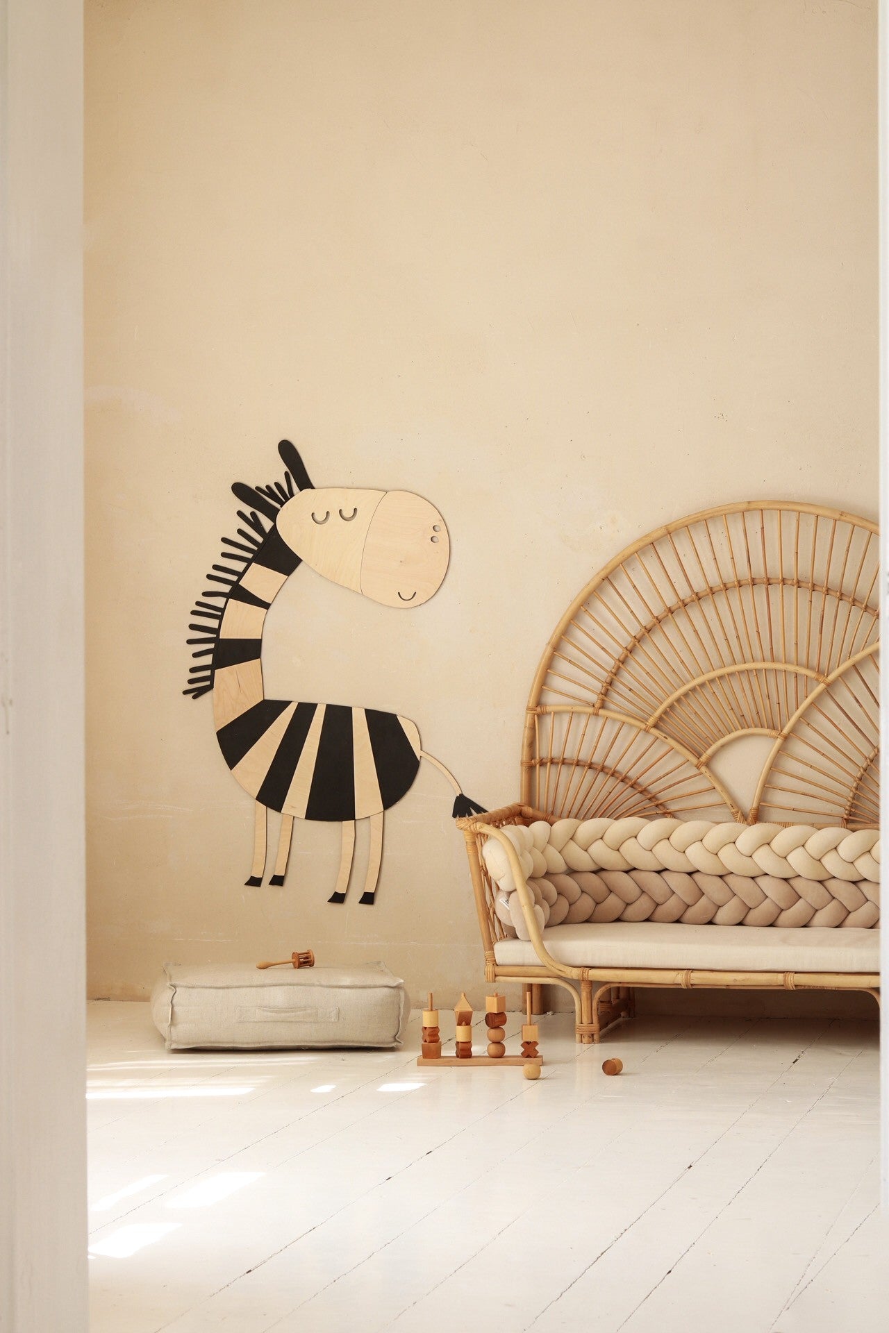 Large wooden safari zebra wall art mounted above natural fiber storage in kids room