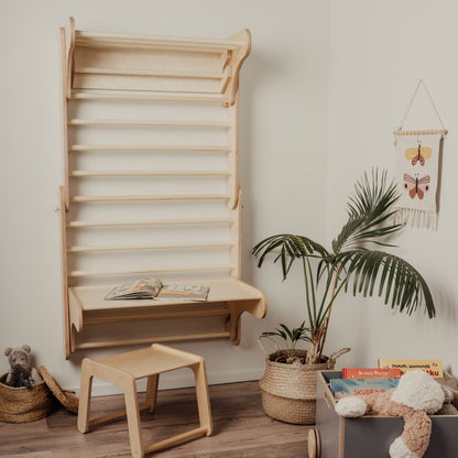 Birch plywood Swedish wall with attached desk shelf and wooden stool in nursery setting