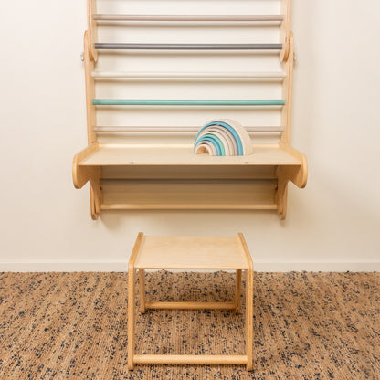 Wooden stool and birch plywood Swedish wall with shelf from front view