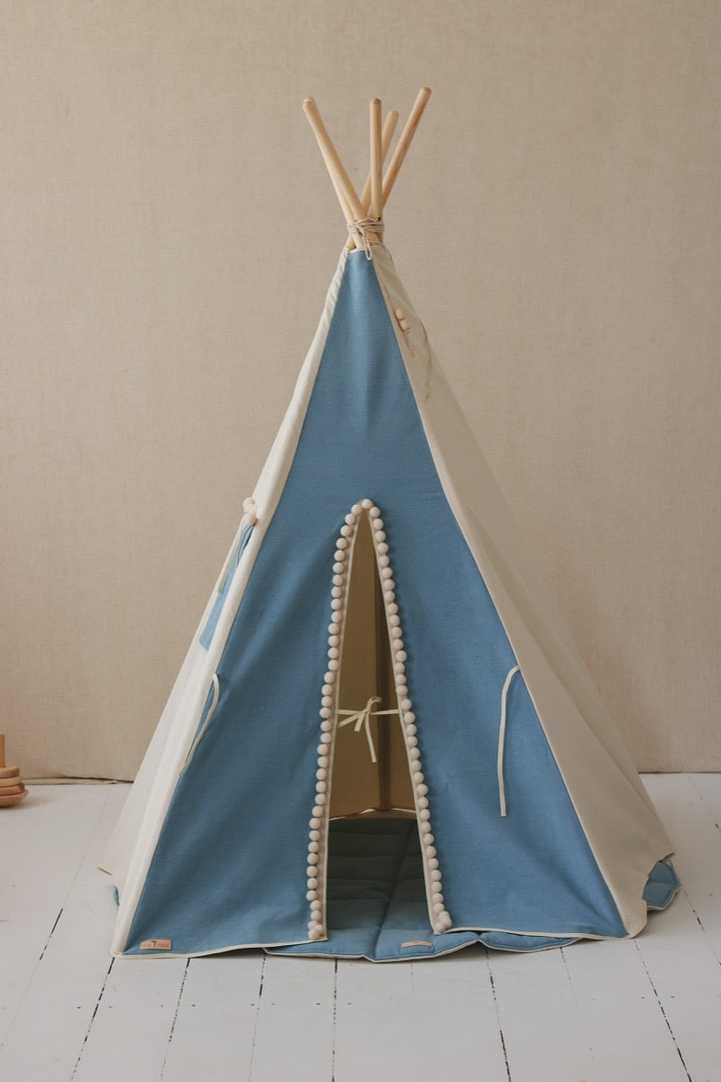 Front view of jeans teepee tent with white and blue panels, pom pom-trimmed entrance, and open doorway