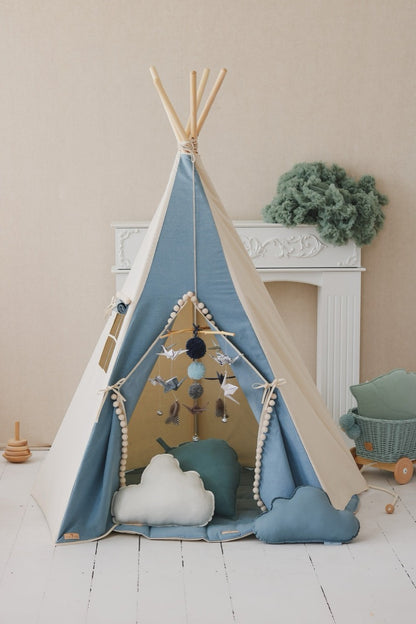 Styled jeans teepee tent in bedroom with cloud pillows, mobile, and woven basket beside it