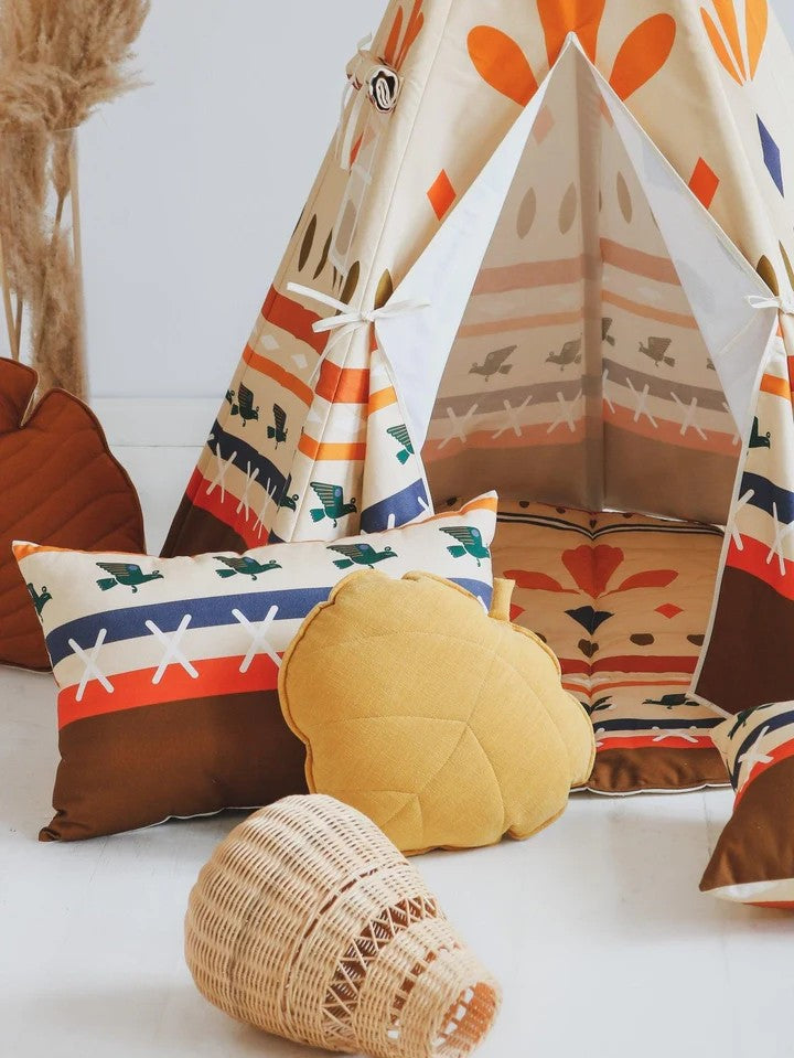 Interior view of Native Vibe teepee tent with yellow round cushion and patterned pillows on woven mat