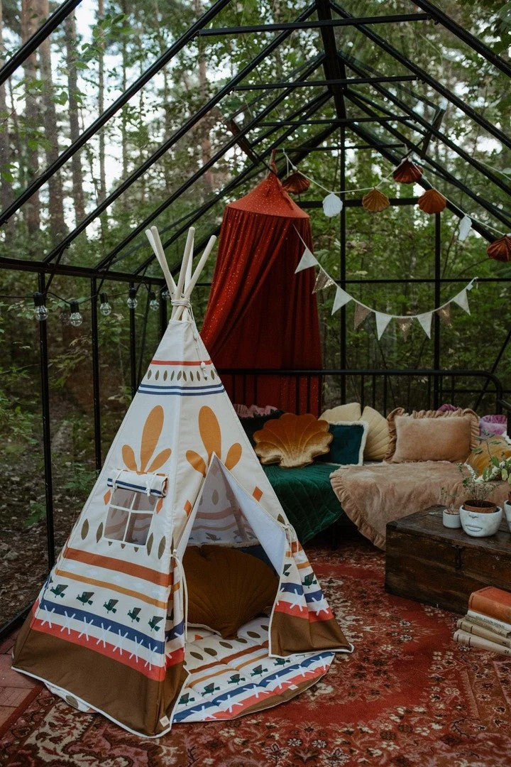 Native Vibe teepee tent set up in greenhouse with cozy seating inside and warm blankets draped nearby