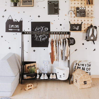 Black Montessori clothing rack styled in nursery with dress-up clothes and accessories
