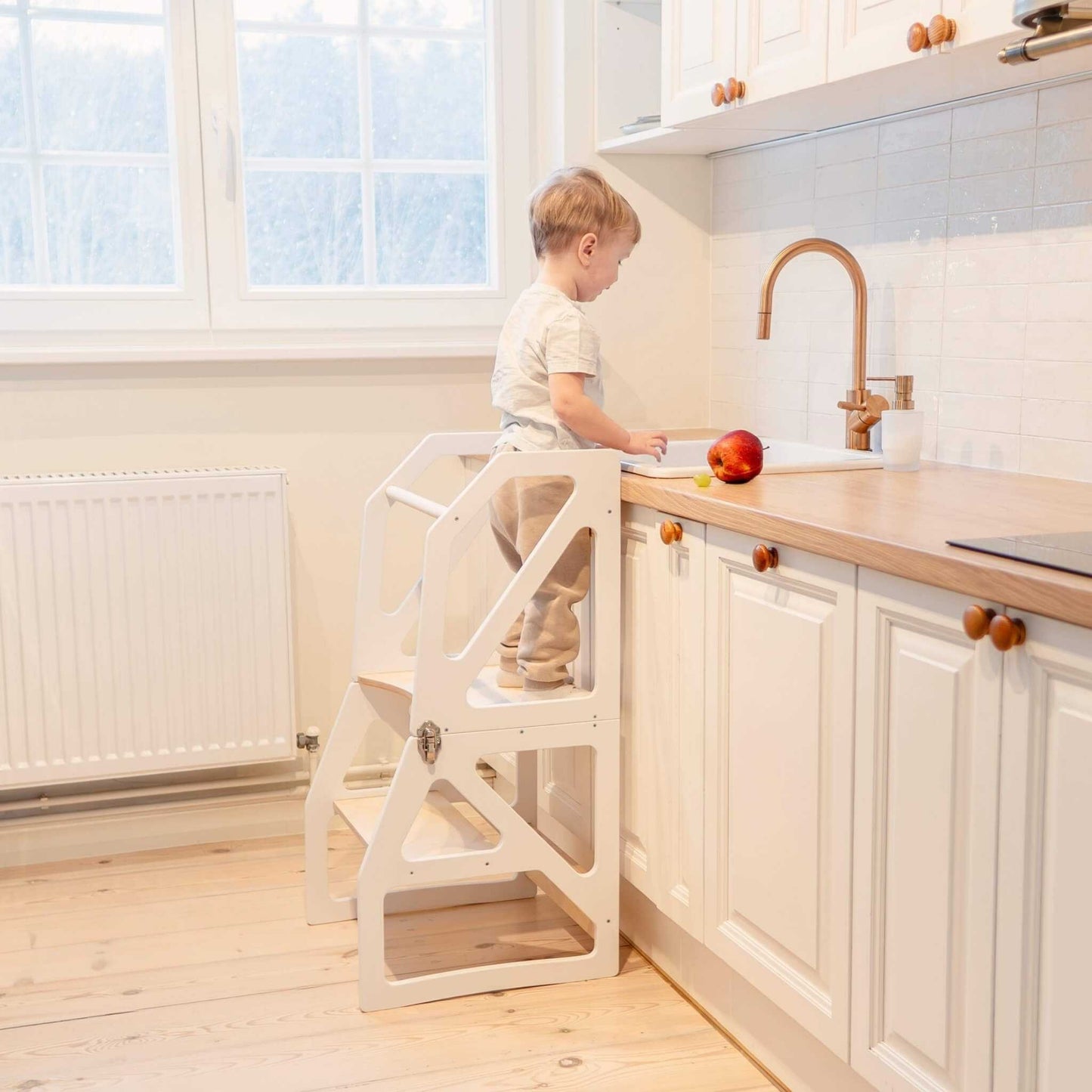 Child accessing kitchen workspace safely with natural wood Modustep tower