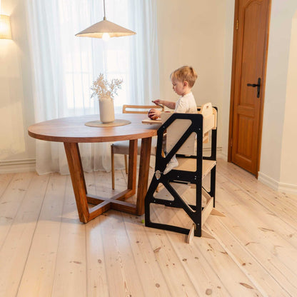 Child at round dining table using black Modustep kitchen tower configuration