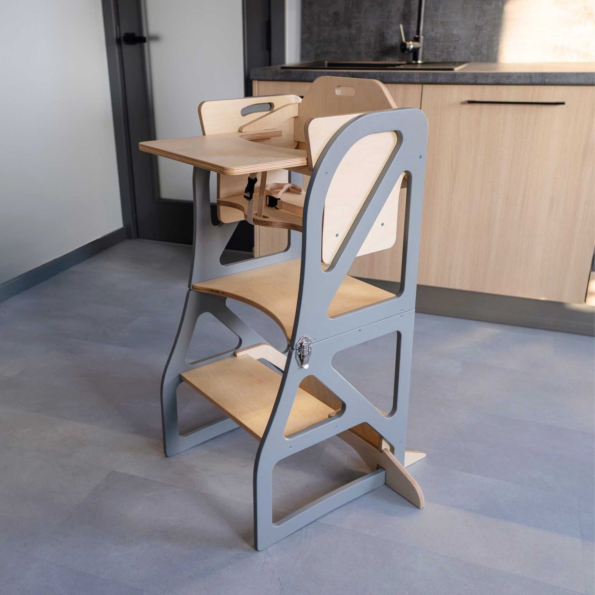 Beige kitchen tower with attached wooden table and chair, angled side view