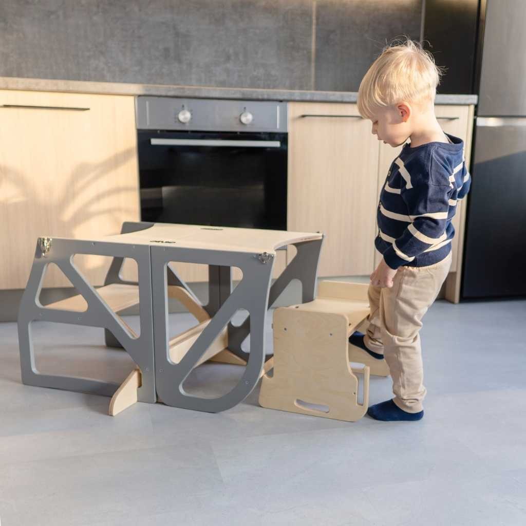 Toddler standing elevated at kitchen counter using beige learning tower