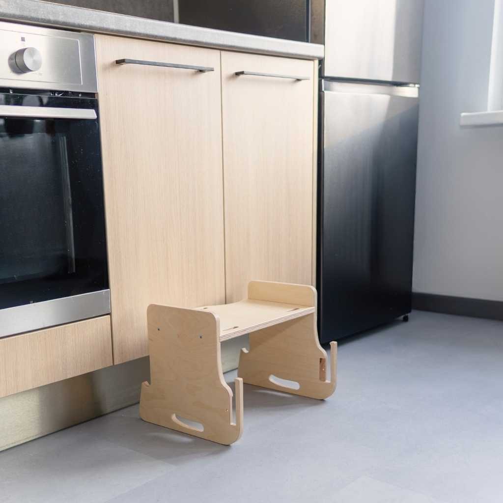 Child eating independently at kitchen tower attached table and chair setup