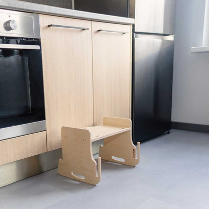 Child eating independently at kitchen tower attached table and chair setup