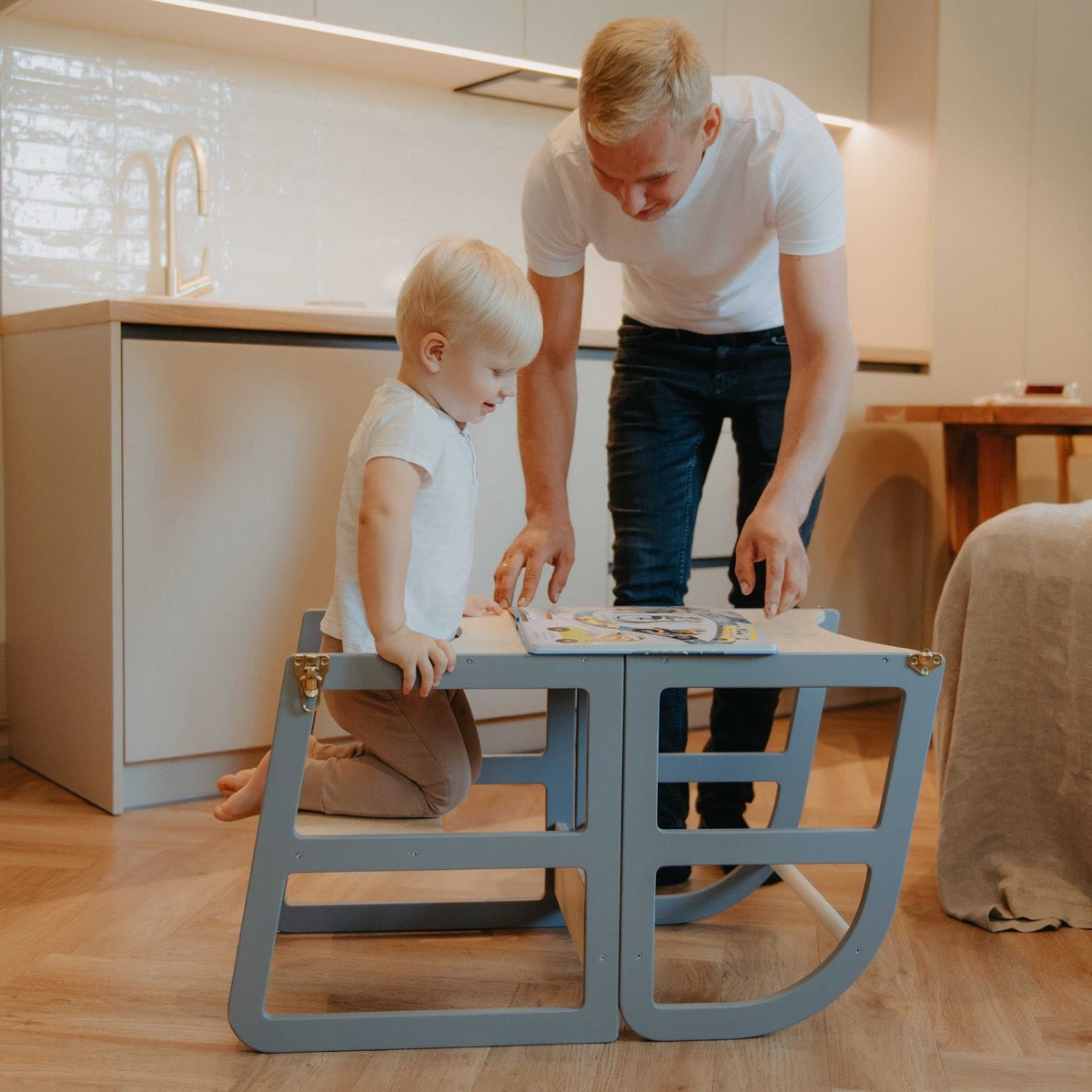 Young child using natural kitchen tower as counter height step stool
