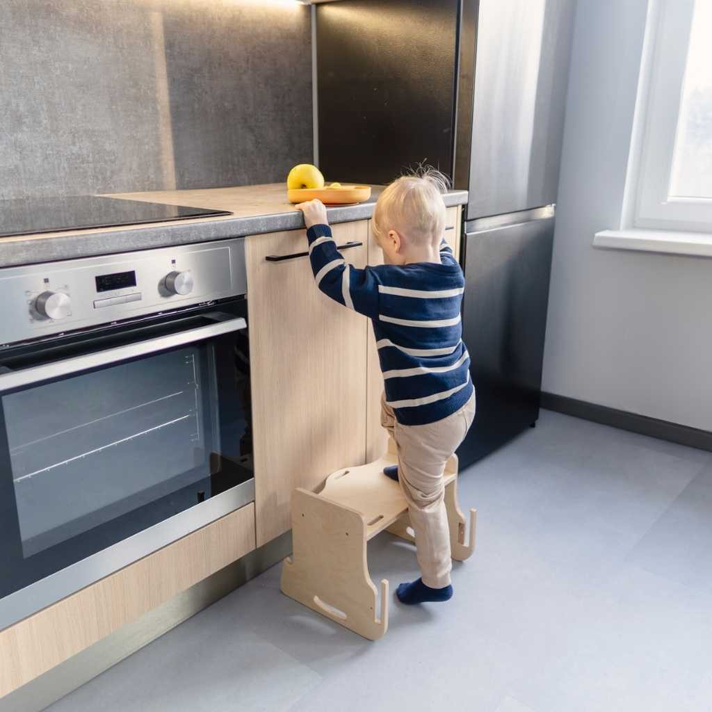 Toddler at grey kitchen tower table playing with toy pattern learning mat