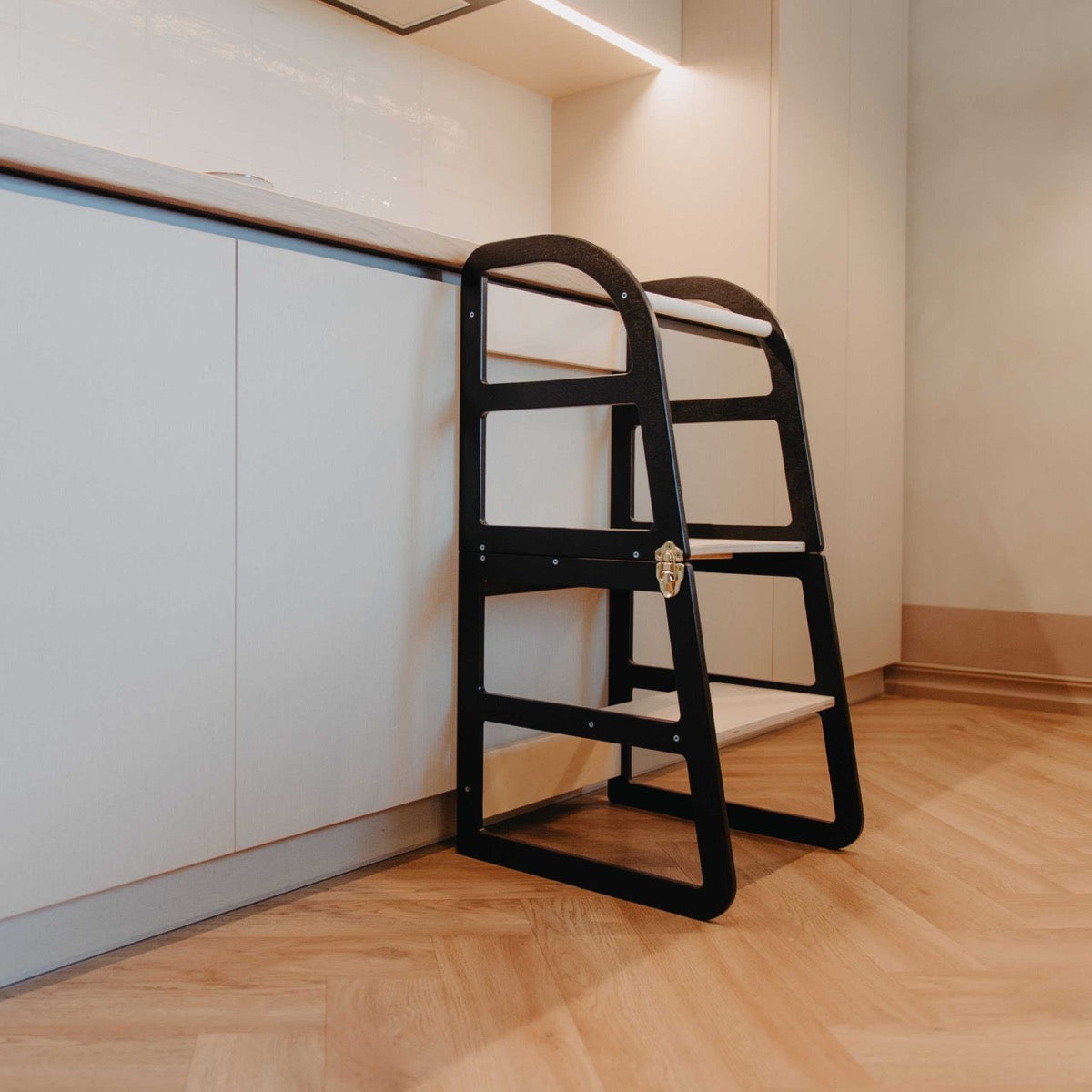 Black kitchen tower with natural wood steps and safety features shown