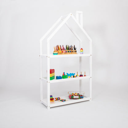White house-shaped shelf with colored pencils, blocks, and toys on display