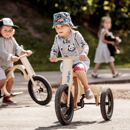Toddler riding leg&go tricycle add-on with three wheels on outdoor pavement