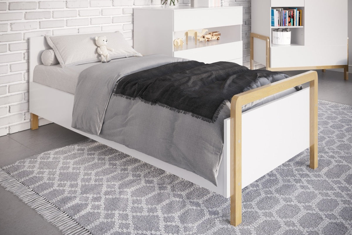 Victor bed side view showing white panels, natural oak frame and slatted base with gray bedding
