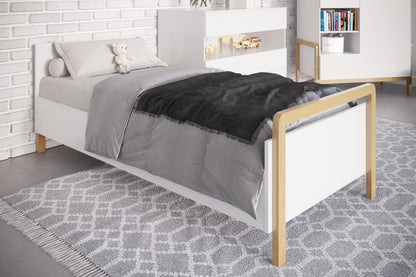 Victor bed side view showing white panels, natural oak frame and slatted base with gray bedding