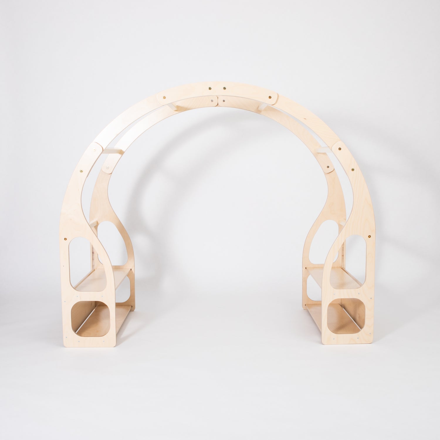 Child crouched inside wooden play stand engaging with toys on built-in shelves