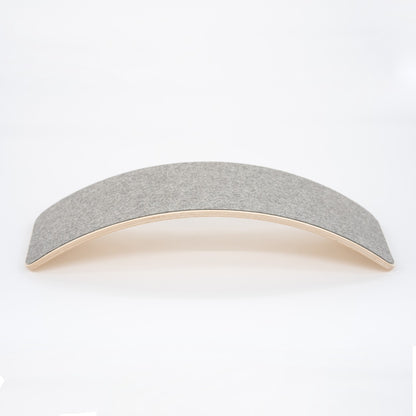 Wooden balance board with grey felt top surface, curved design side view