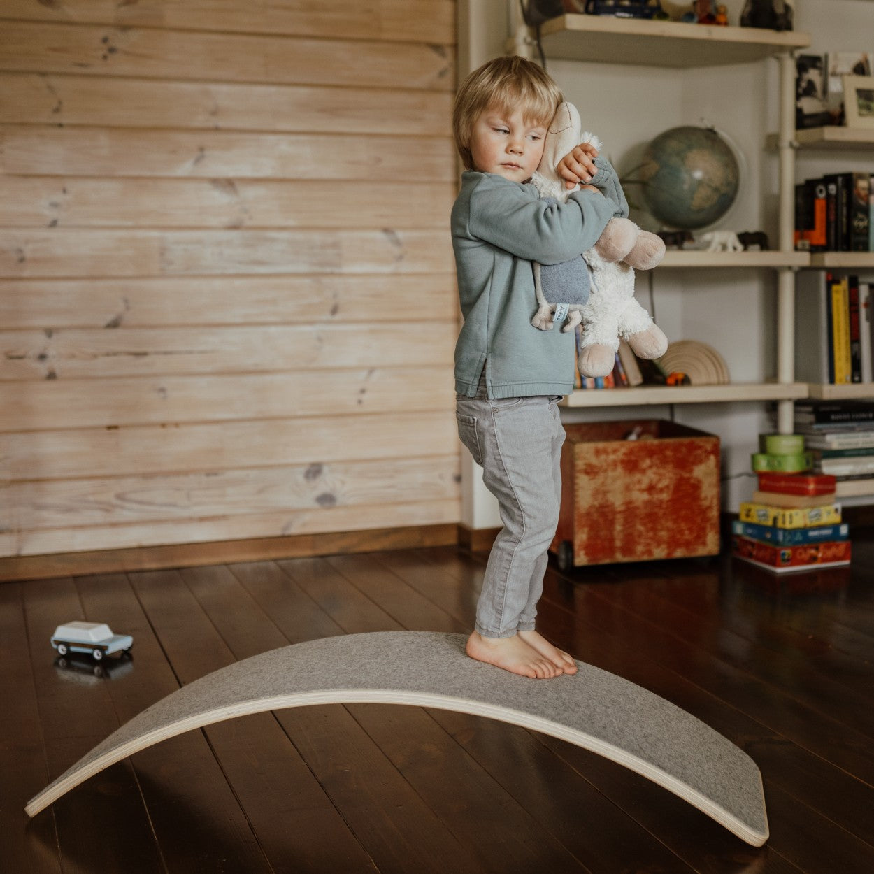 Toddler standing on balance board working on coordination and gross motor skills