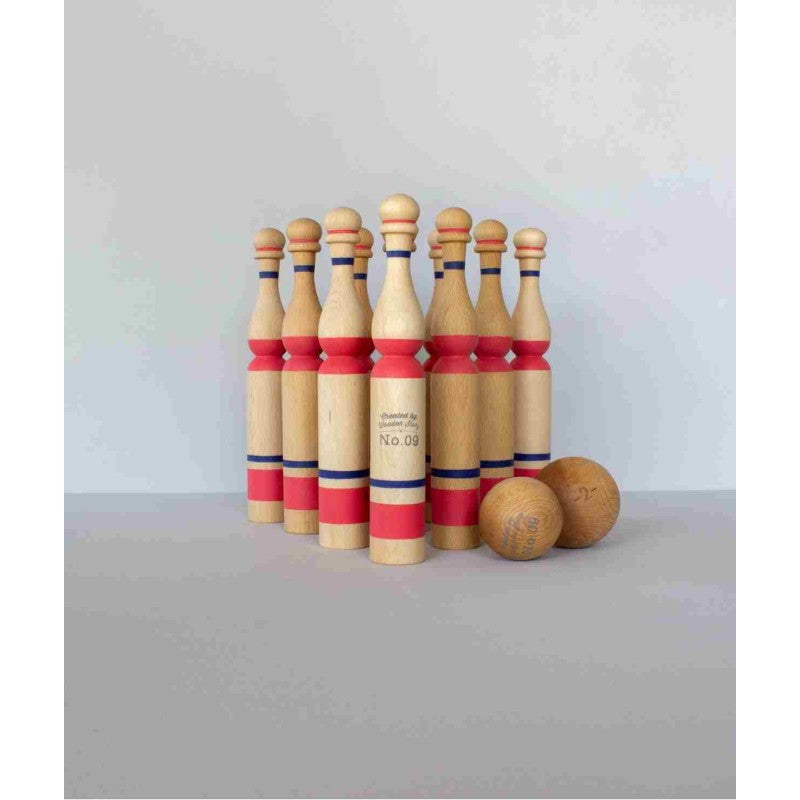 Complete wooden bowling pin set displayed with pins standing and two wood balls positioned in front