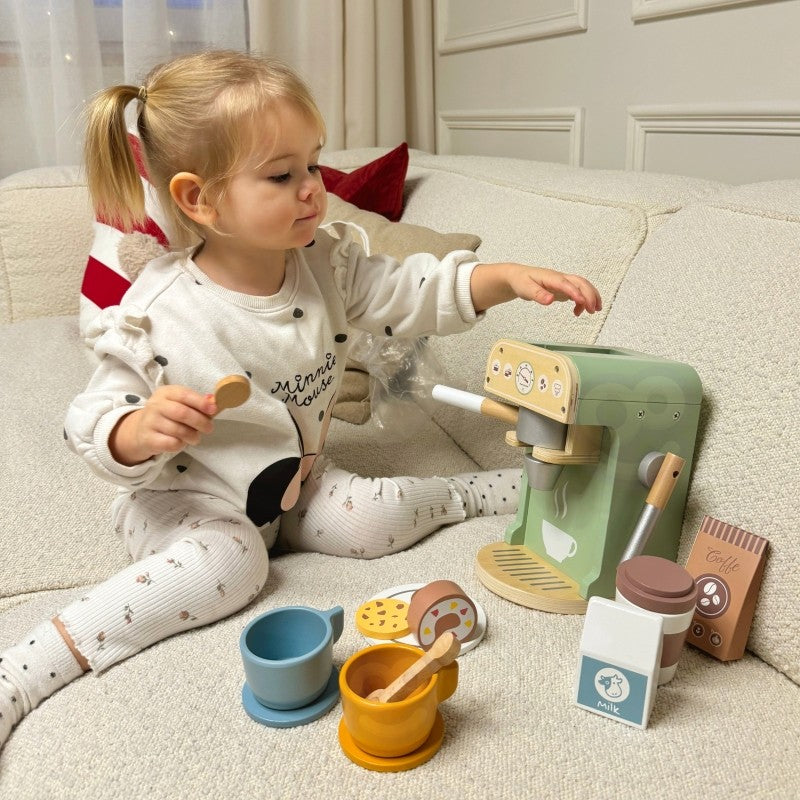 Child using wooden coffee maker with portafilter, pastry cookies displayed on plate during role-play
