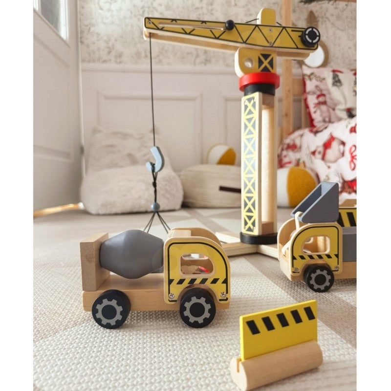 Wooden dump truck carrying gray cargo block beneath rotating crane with lifting hook