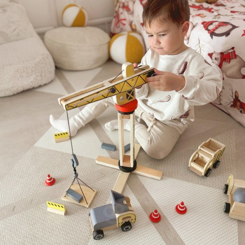 Toddler hands manipulating wooden construction vehicle during active Montessori-style play