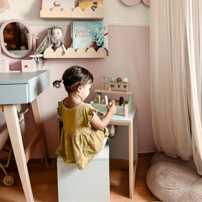Wooden ice cream shop set positioned on bedroom shelf next to decorative items and books