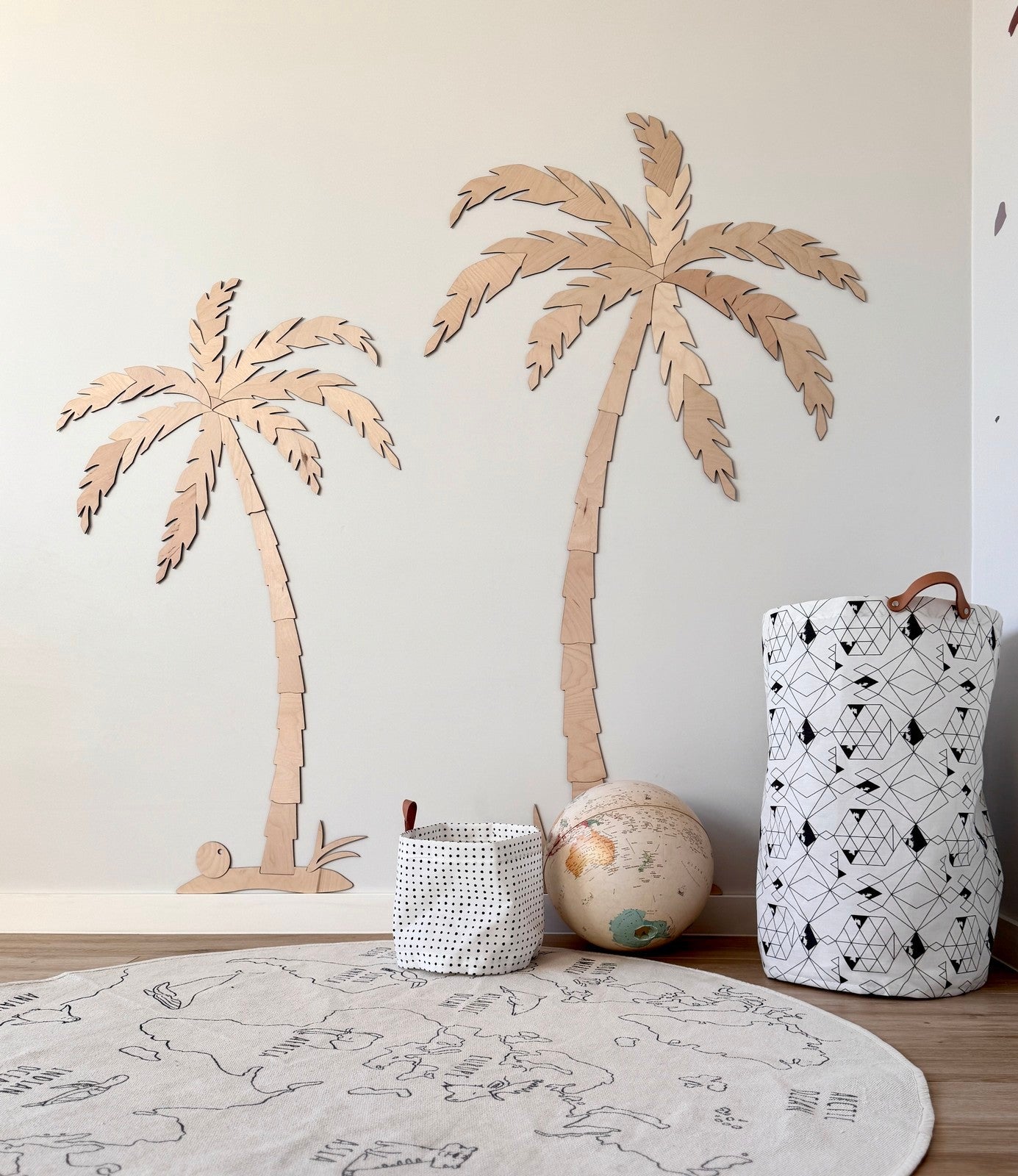 Two wooden palm trees of different sizes displayed as tropical wall decor set