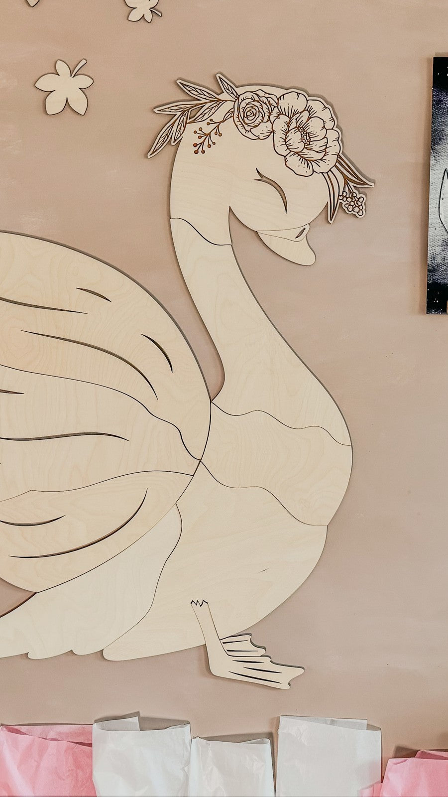 Side view of complete wooden swan wall decoration with layered plywood wings and floral headpiece