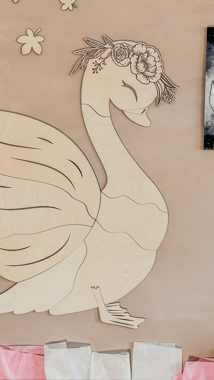 Side view of complete wooden swan wall decoration with layered plywood wings and floral headpiece